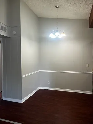 a view of a room with wooden floor and ceiling fan