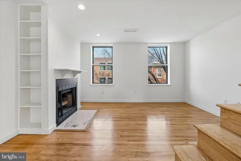 a view of an empty room with a window and fireplace