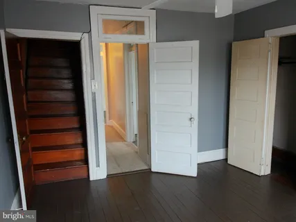 a white toilet sitting next to a window in a bathroom