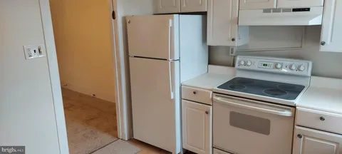a view of a kitchen with wooden floor and cabinets