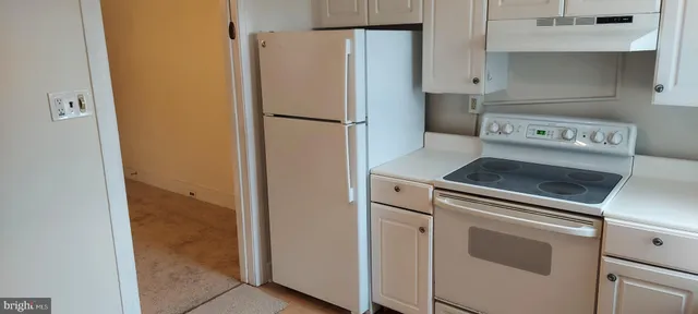 a view of a kitchen with wooden floor and cabinets