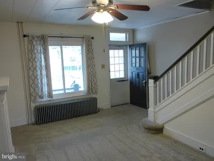 an empty room with windows and ceiling fan