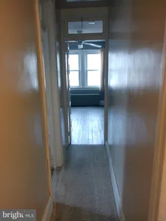 a view of a hallway with wooden floor and closet