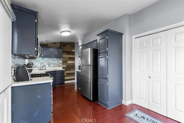 a kitchen with stainless steel appliances granite countertop a refrigerator and a stove top oven