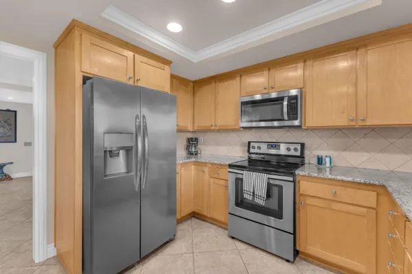 a kitchen with stainless steel appliances granite countertop a refrigerator and a stove top oven