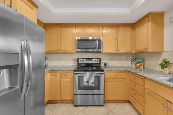 a kitchen with stainless steel appliances granite countertop a stove a sink and a refrigerator