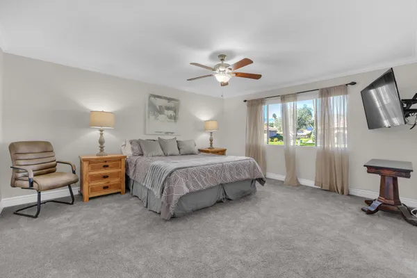 a spacious bedroom with a bed and a chair