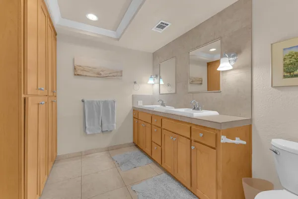 a bathroom with a double vanity sink mirror and toilet
