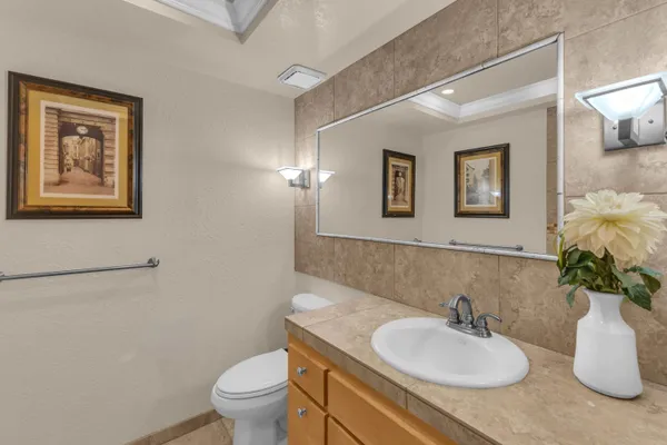 a bathroom with a granite countertop sink toilet and a mirror