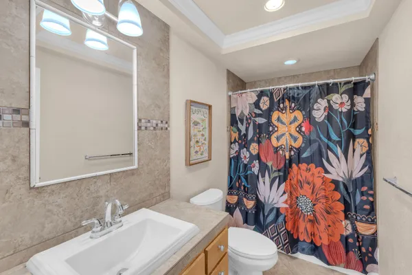 a bathroom with a sink toilet and shower curtain
