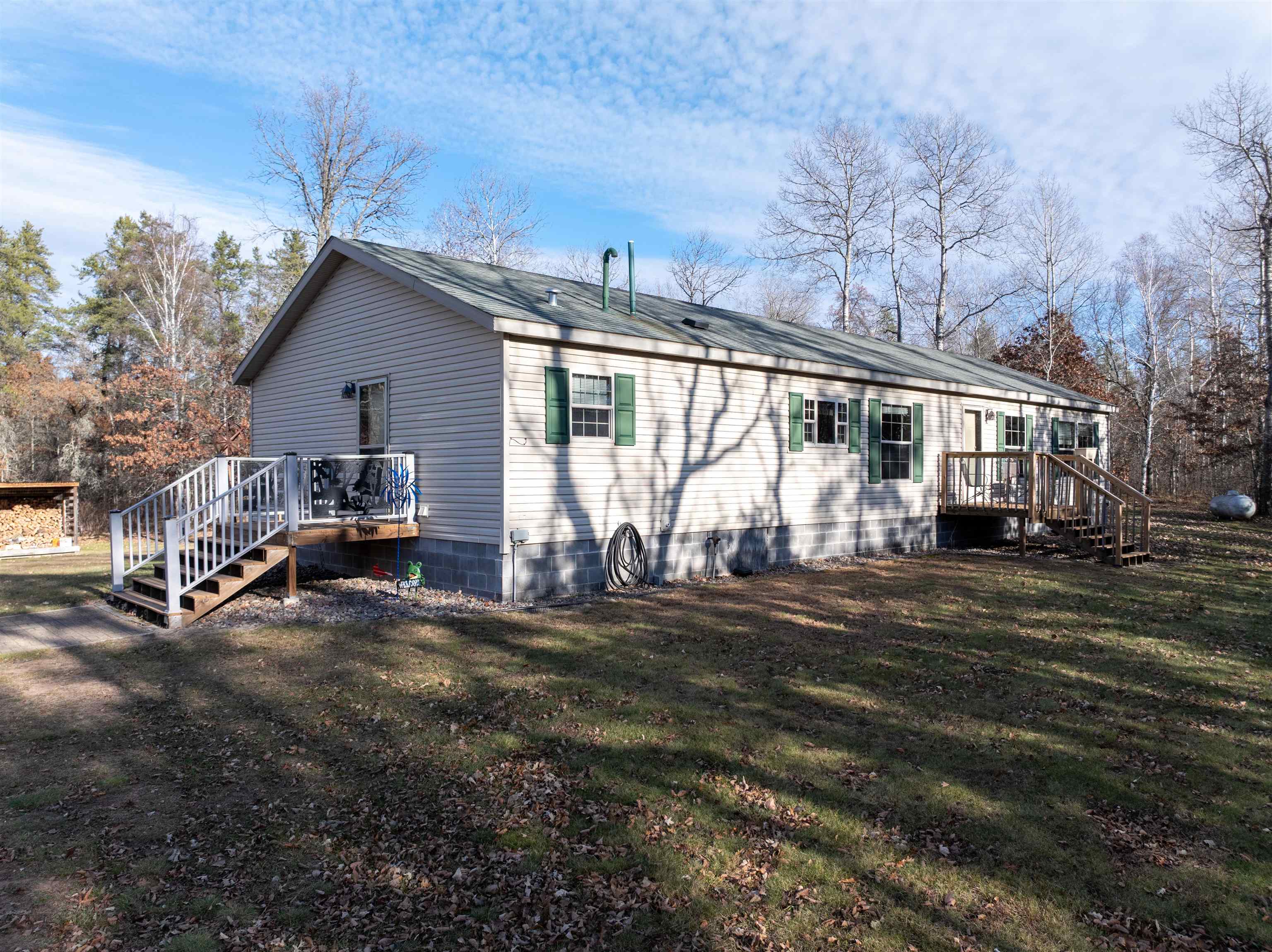 Back of house featuring stairway, a deck, and a lawn