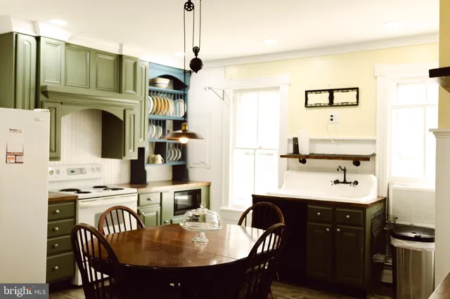 a kitchen with stainless steel appliances granite countertop a sink a stove and chairs