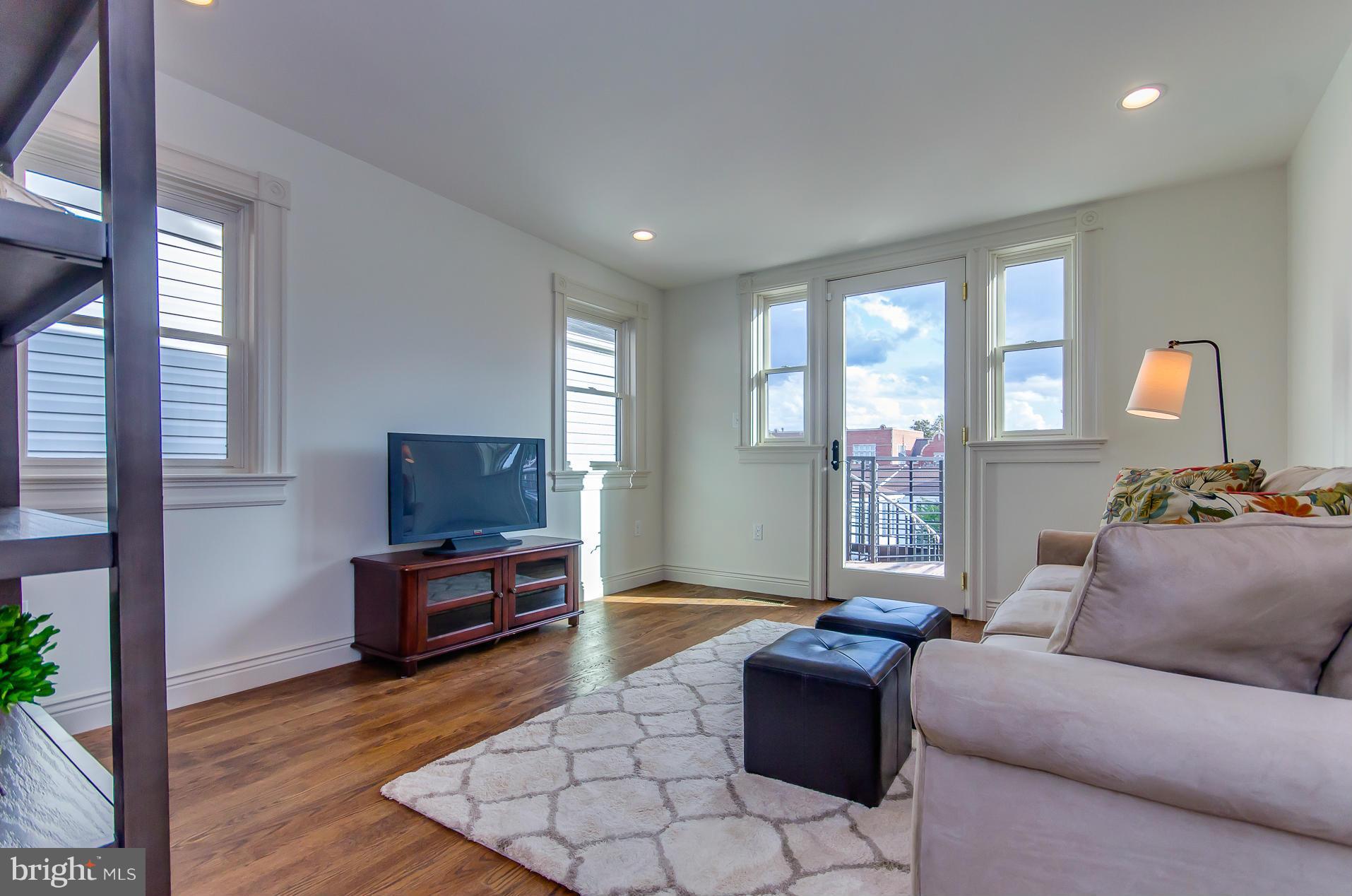1128 Columbia Road Northwest Washington, DC 20009 - Photo 16 of 26 a living room with furniture and a flat screen tv