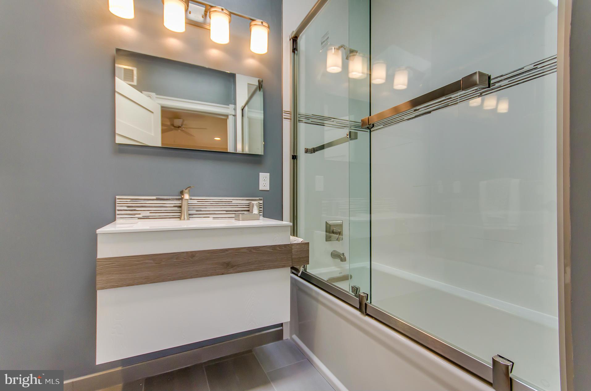 1128 Columbia Road Northwest Washington, DC 20009 - Photo 18 of 26 a bathroom with a bathtub and a mirror
