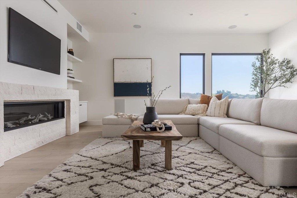 2942 Lone Jack Road Encinitas, CA 92024 - Photo 14 of 23 a living room with furniture a flat screen tv and a fireplace