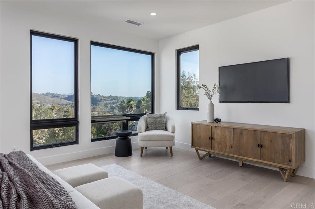 2942 Lone Jack Road Encinitas, CA 92024 - Photo 16 of 23 a living room with furniture a flat screen tv and a floor to ceiling window