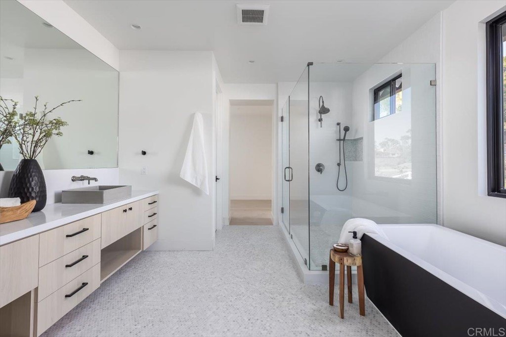 2942 Lone Jack Road Encinitas, CA 92024 - Photo 17 of 23 a spacious bathroom with a double vanity sink a large mirror a shower and bathtub
