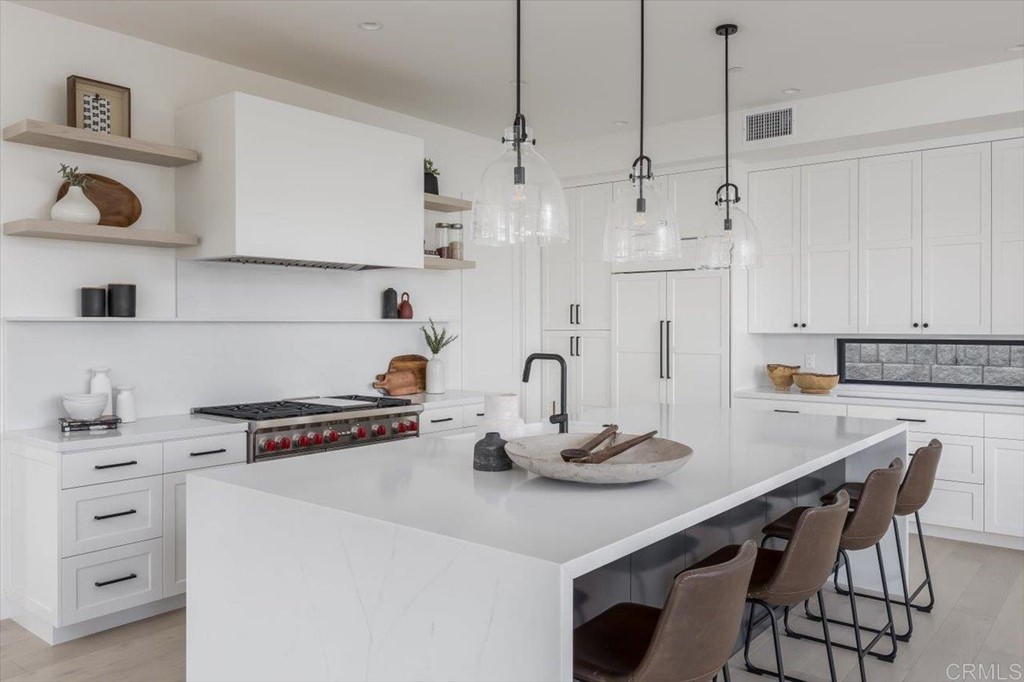 2942 Lone Jack Road Encinitas, CA 92024 - Photo 7 of 23 a kitchen with a table a stove and white cabinets