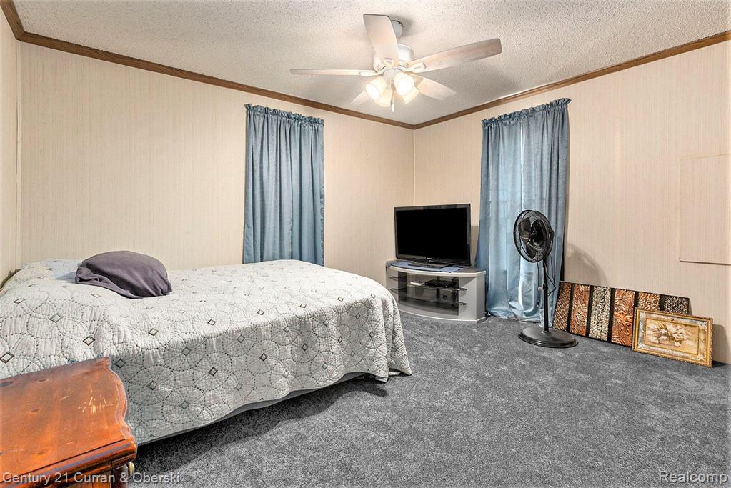 10228 Rexford Road Grass Lake, MI 49240 - Photo 13 of 24 Bedroom featuring ornamental molding, carpet floors, ceiling fan, and a textured ceiling