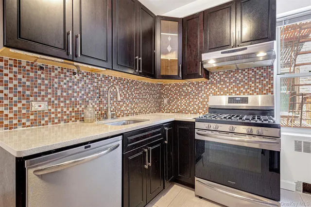 a kitchen with granite countertop cabinets stainless steel appliances and wooden floor