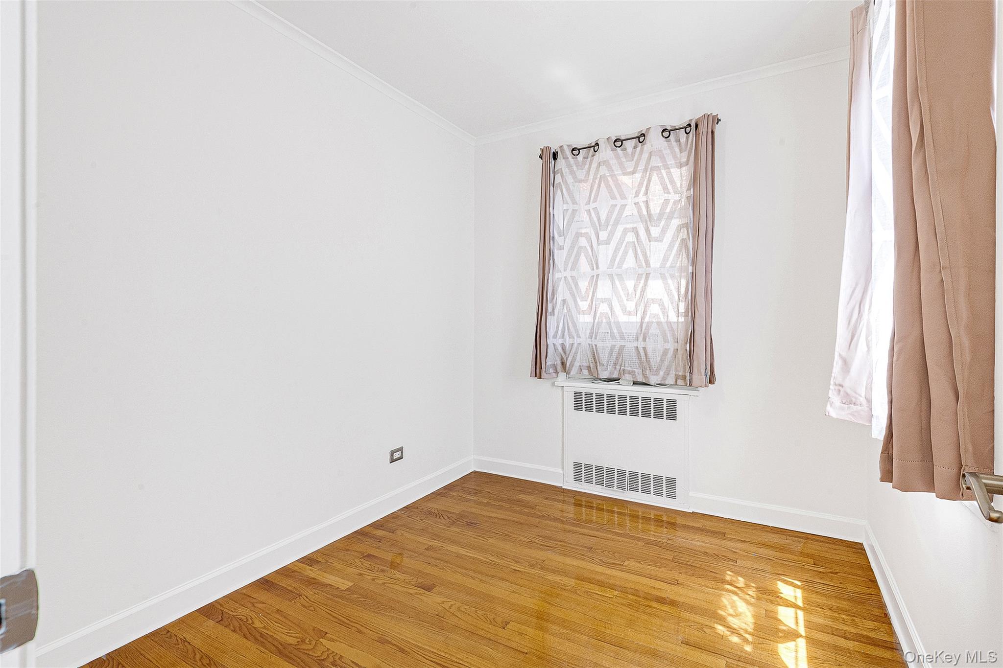 67-38 108th Street, Unit D47 Queens, NY 11375 - Photo 16 of 24 a view of an empty room with wooden floor and a window