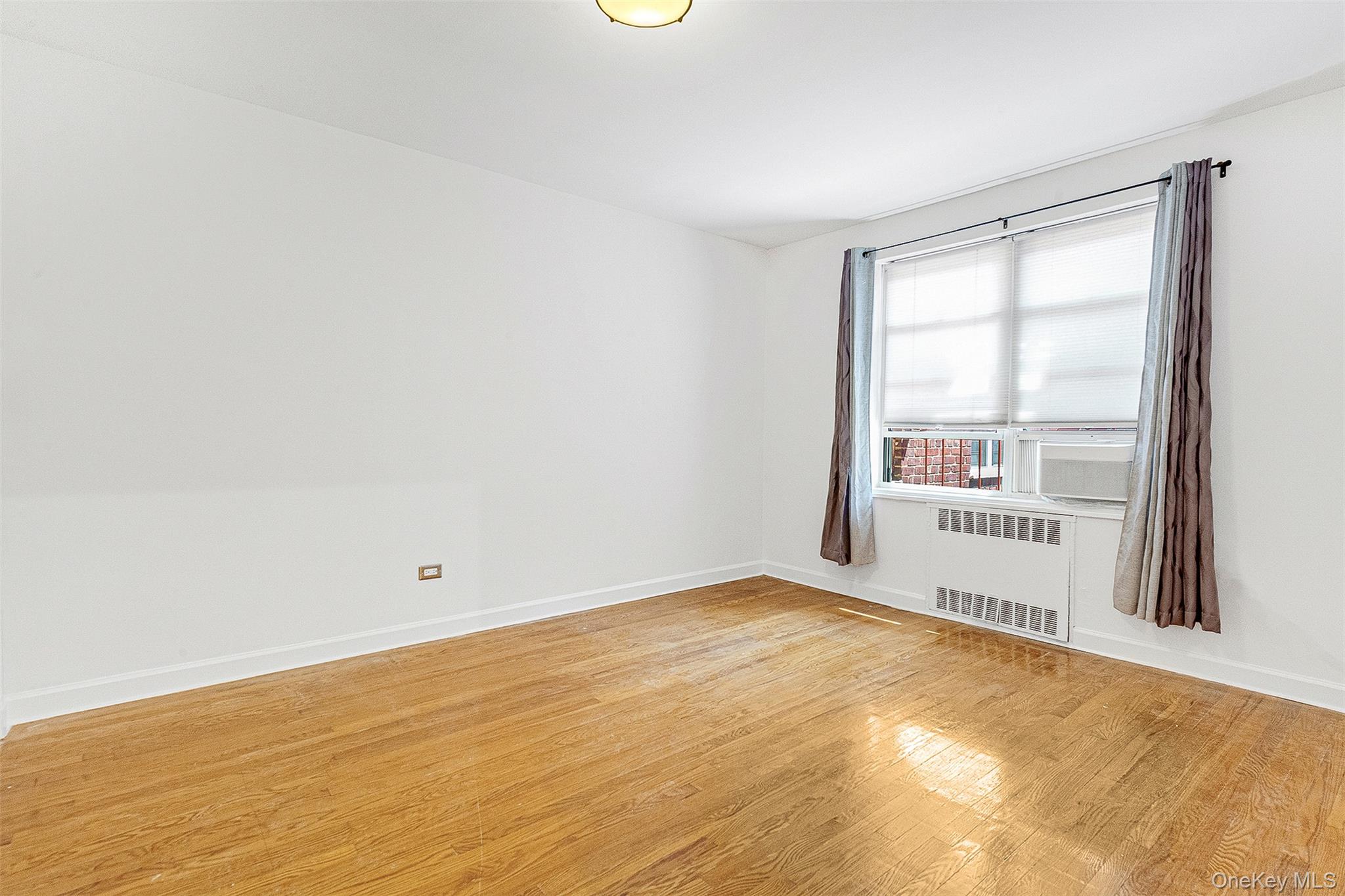 67-38 108th Street, Unit D47 Queens, NY 11375 - Photo 21 of 24 an empty room with a empty space and a window
