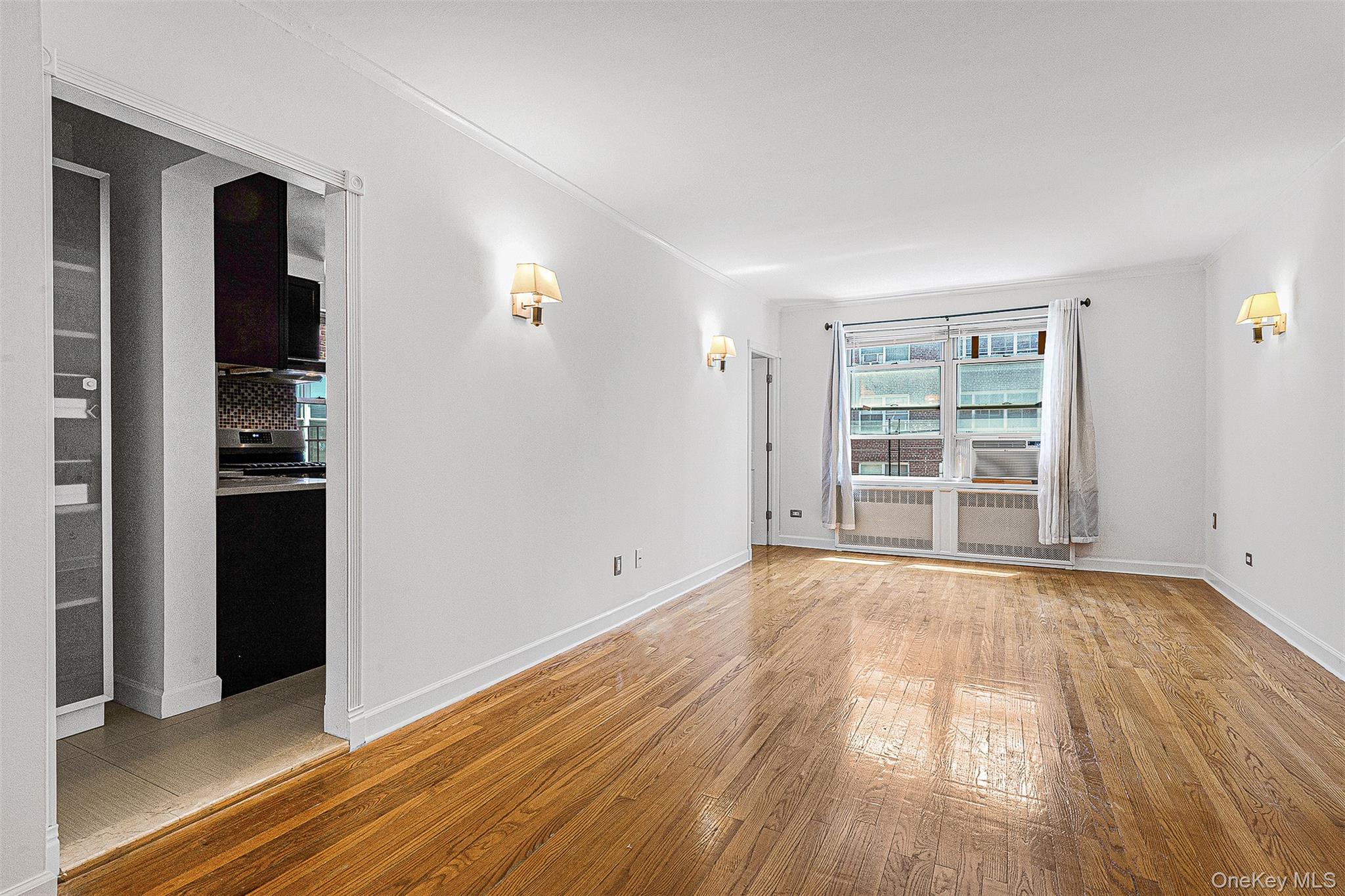 67-38 108th Street, Unit D47 Queens, NY 11375 - Photo 8 of 24 wooden floor in an empty room and a window