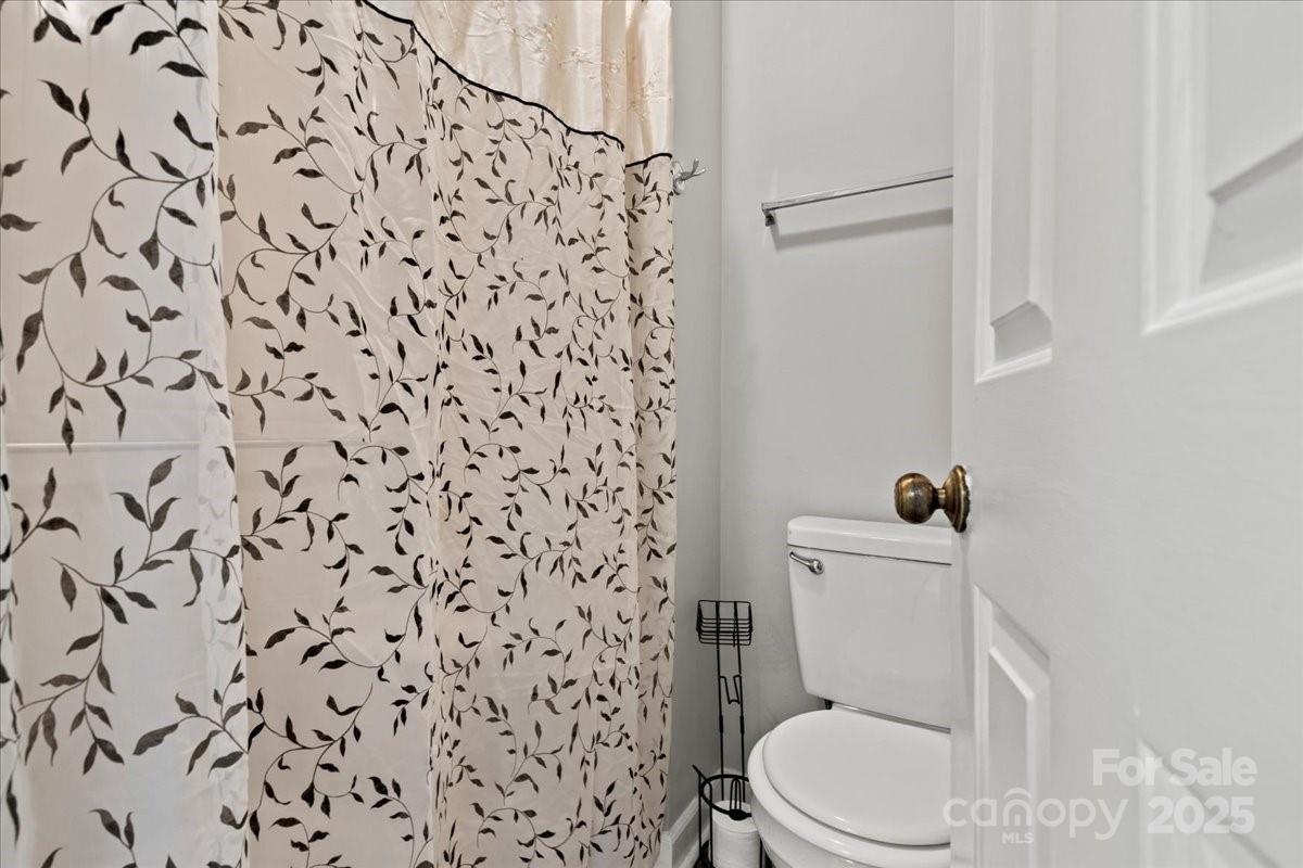 305 Virginia Avenue Cheraw, SC 29520 - Photo 13 of 48 a white toilet sitting next to a shower curtain