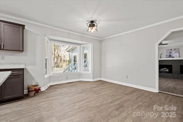 a view of an empty room with a window and a fireplace