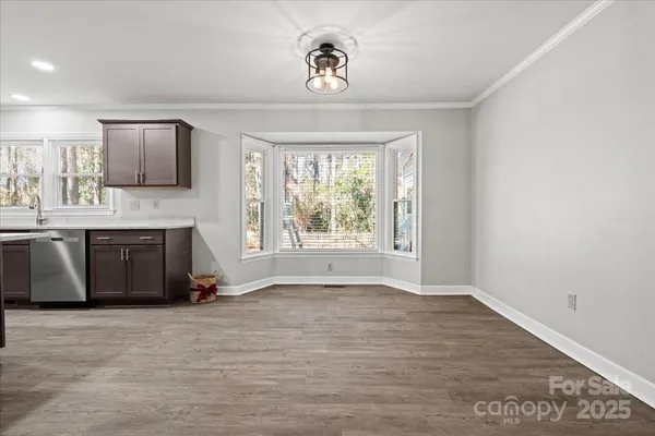 a view of an empty room with a window and fireplace