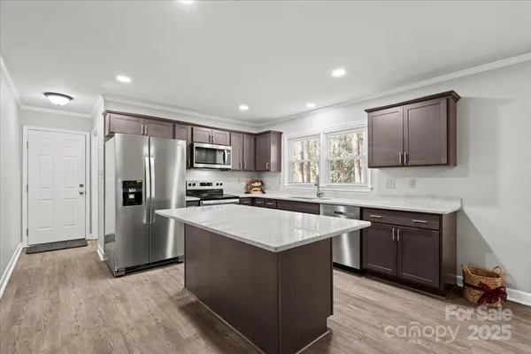 a kitchen with stainless steel appliances granite countertop a sink stove and refrigerator