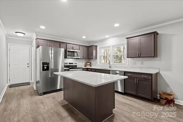 a kitchen with stainless steel appliances granite countertop a sink stove and refrigerator