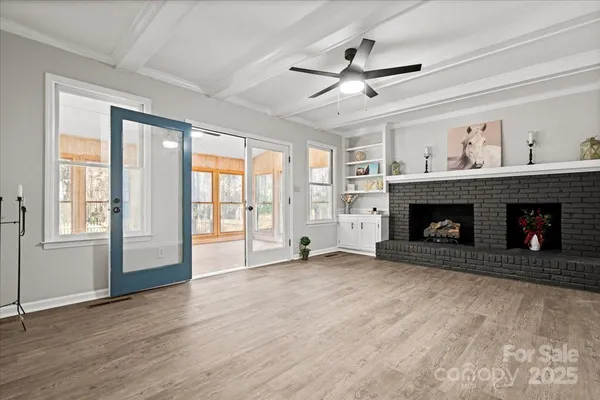 a view of an empty room with a fireplace and a window