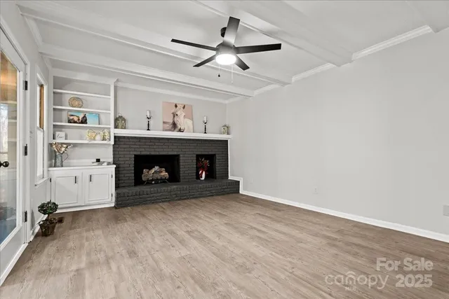 a view of an empty room with a fireplace and a window