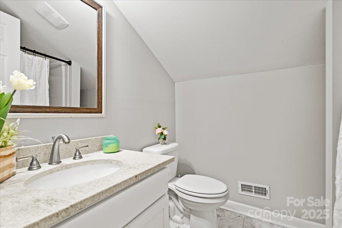 305 Virginia Avenue Cheraw, SC 29520 - Photo 43 of 48 a bathroom with a granite countertop sink mirror vanity and toilet