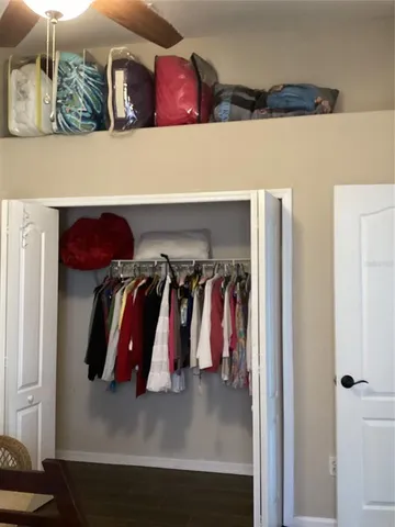 a view of walk in closet with clothes and shoes