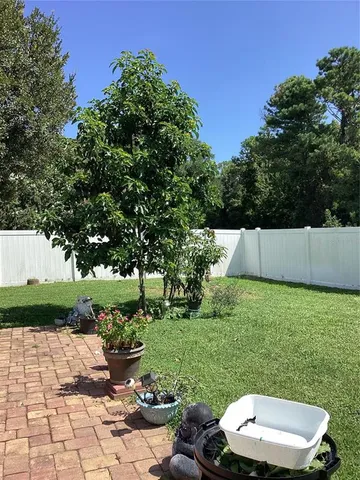 a view of a patio with table and chairs potted plants and a large tree