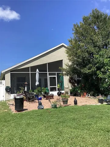 a view of a house with potted plants and a bench