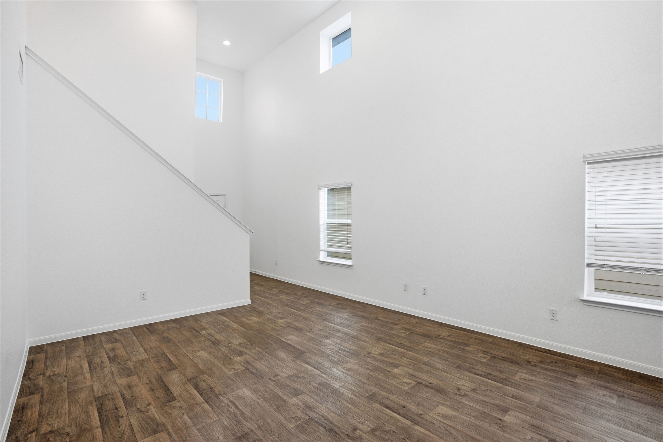 3009 Tilmon Ln. Austin, TX 78725 - Photo 11 of 33 Unfurnished living room with dark wood-style floors and a high ceiling