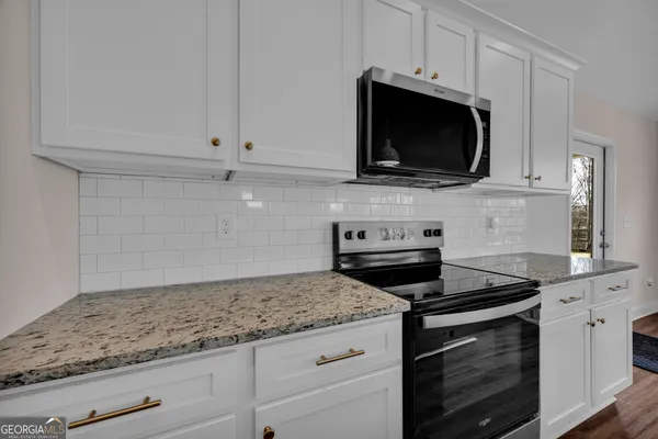 a bathroom with a granite countertop sink a mirror and shower