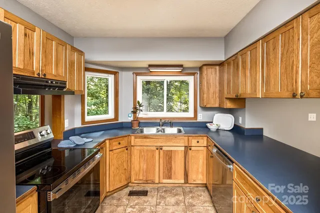 a kitchen with a sink a counter top space and stainless steel appliances