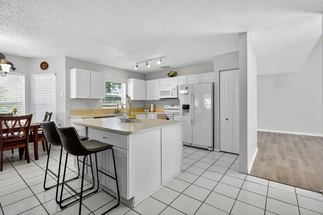 a kitchen with cabinets appliances a sink and a window