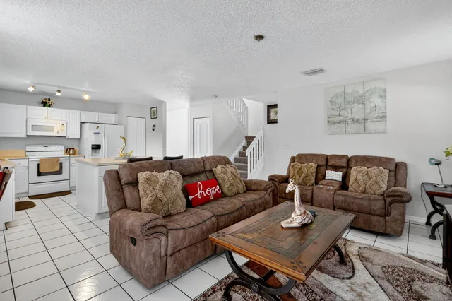a living room with furniture a rug and wooden floor