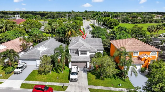 an aerial view of a residential houses with outdoor space and lake view