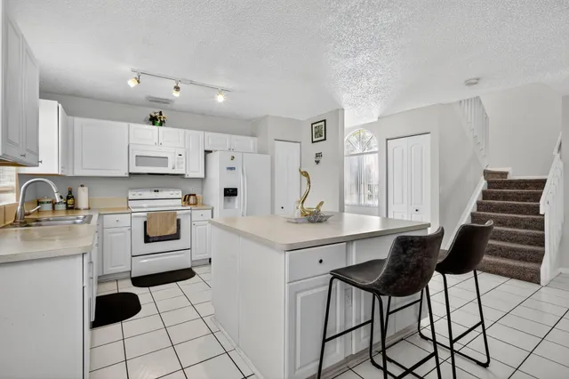 a kitchen with white cabinets and white appliances