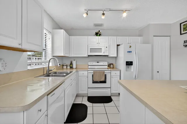 a kitchen with white cabinets and white appliances