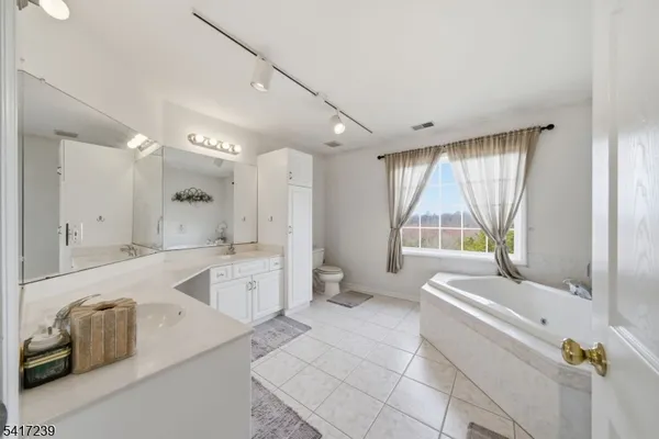 a spacious bathroom with a double vanity sink mirror and toilet
