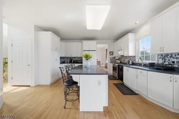 a view of a dining room and livingroom with furniture wooden floor a chandelier