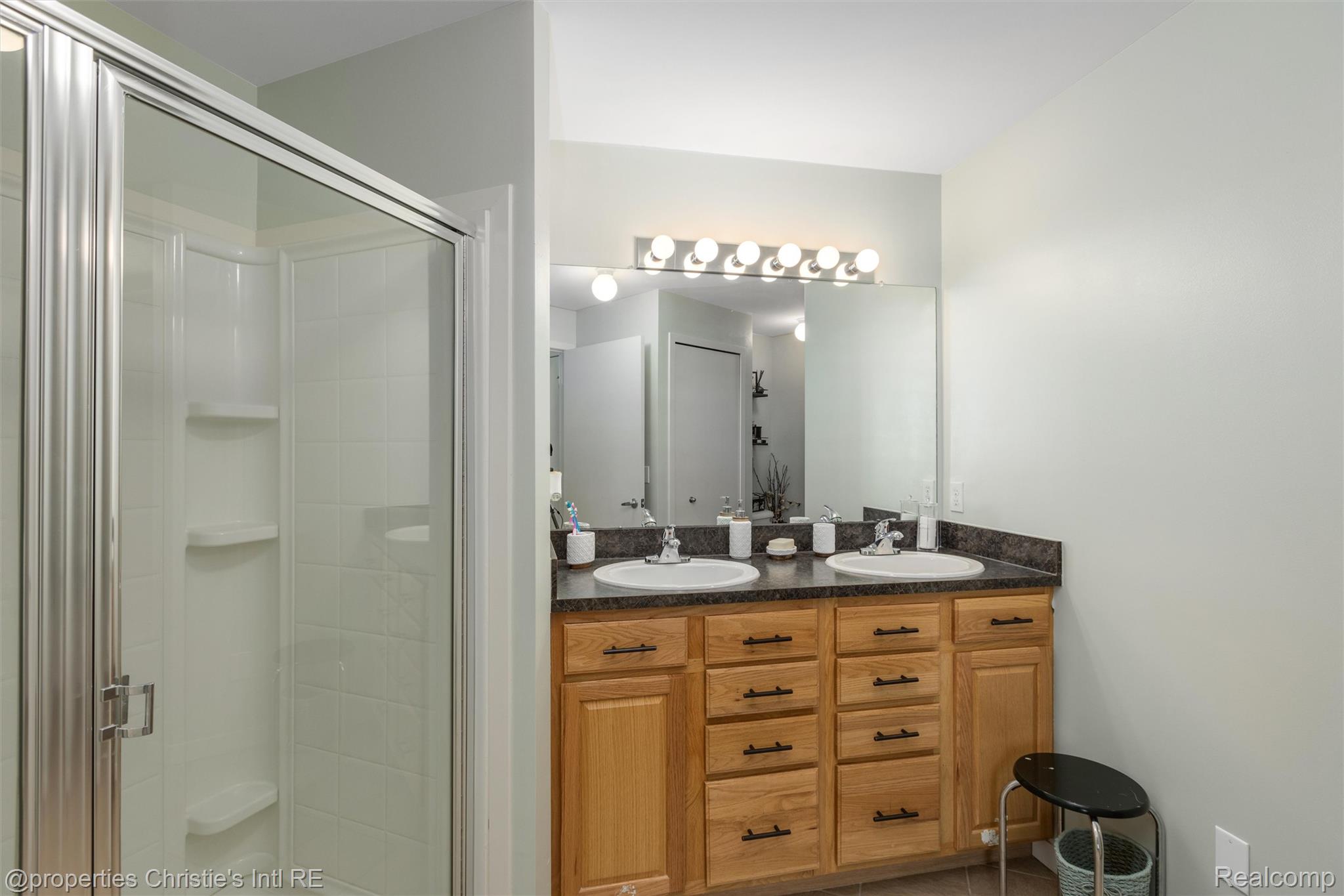 66 Winder Street, Unit 332 Detroit, MI 48201 - Photo 15 of 30 Full bath featuring double vanity, a shower stall, and light tile patterned floors