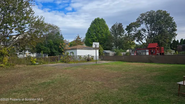 a view of a big house with a big yard and large trees